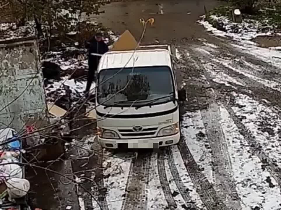 Неизвестный мужчина выбрасывает строительный мусор на контейнерной площадке в Хабаровске